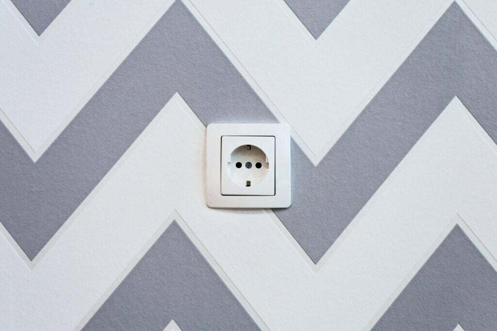 white power strip mounted on white and grey chevron painted wall