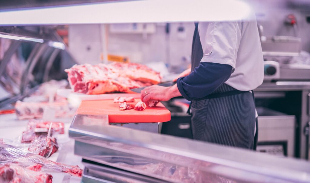 man slicing raw meat